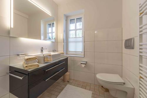 een witte badkamer met een wastafel en een toilet bij Ferienwohnung Dünenblick in Sankt Peter-Ording