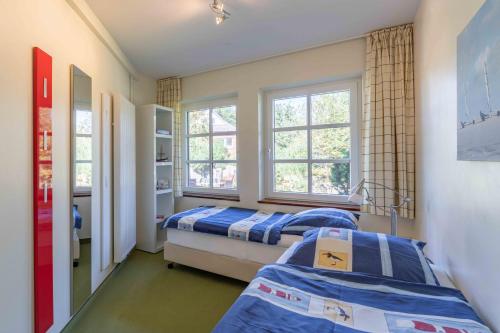 two beds in a room with two windows at Ferienwohnung Dünenblick in Sankt Peter-Ording