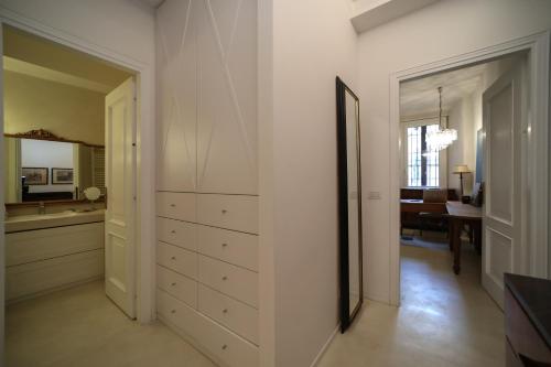 a white hallway with a dresser and a mirror at Pallata 52 in Brescia