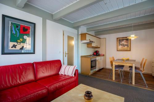 a living room with a red couch and a table at Atlanta Pur in Pellworm