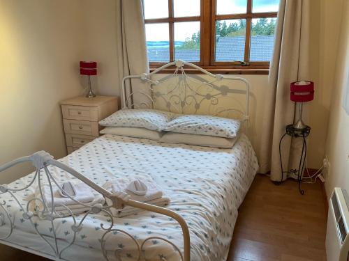 een slaapkamer met een wit bed en een raam bij Culloden Apartment Free Parking in Inverness