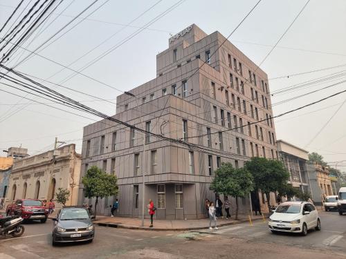 un edificio alto con coches estacionados frente a él en Monoambiente temporal Jujuy en San Salvador de Jujuy