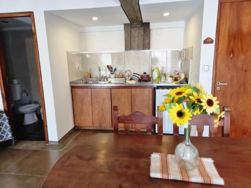 una cocina con un jarrón de flores sobre una mesa en Monoambiente temporal Jujuy en San Salvador de Jujuy