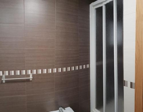 a bathroom with a toilet and a wooden wall at PIEDAD FERNANDEZ FERNANDEZ GESTION DE INMUEBLES - III in O Barqueiro