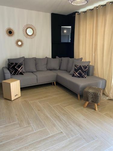 - un salon avec un canapé gris et du parquet dans l'établissement La palmera, à Frontignan