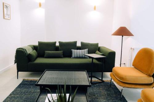 sala de estar con sofá verde y silla en Outsite Bordeaux en Burdeos