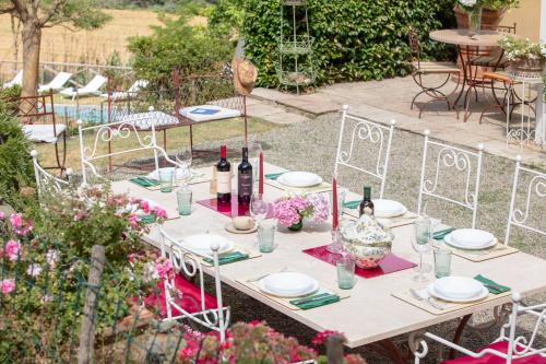 a table with plates and wine bottles on it at Villa Ginevra by Tenuta di Ghizzano in Ghizzano