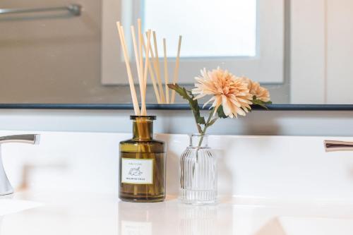 a vase with a flower and a vase with sticks in it at Brand New Entire Home close to beach in Saint Augustine