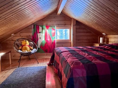 a bedroom with a bed with a teddy bear in a basket at Pyhä Nallentupa in Pyhätunturi