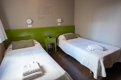 two beds in a room with green walls at Hotel Posada Del Sol in Salta