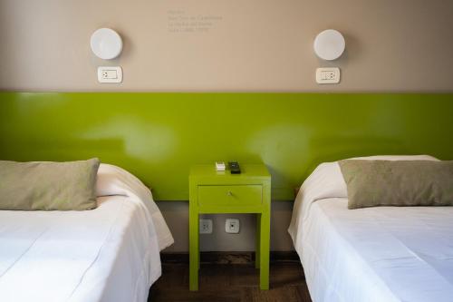 a room with two beds and a green wall at Hotel Posada Del Sol in Salta