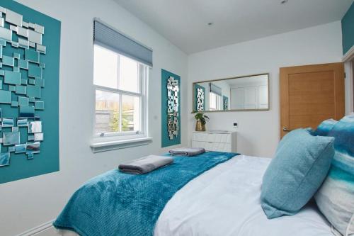 a bedroom with a bed with two pillows on it at Beautiful Central Apartment in Leamington Spa
