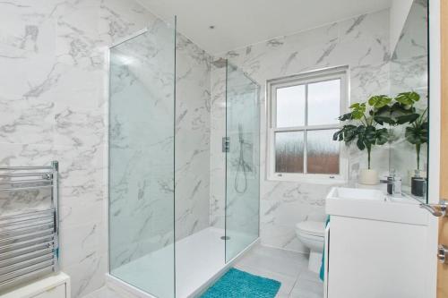 La salle de bains est pourvue d'une douche en verre et de toilettes. dans l'établissement Beautiful Central Apartment, à Leamington Spa