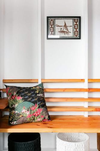a wooden bench in a room with a picture on the wall at THE OHANA HOUSE, Amazing Tiny Home on A Volcanic Lava Field! in Kehena
