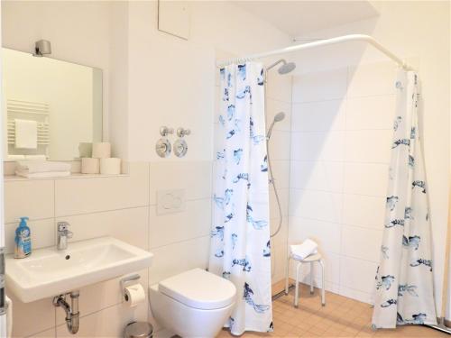 a white bathroom with a toilet and a sink at Braviscasa - Ferienresidenz Stadttor Endingen in Endingen
