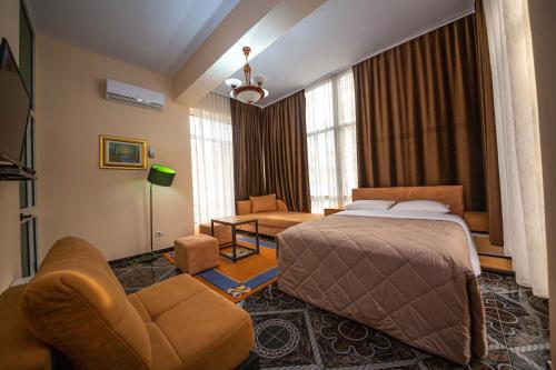 une chambre d'hôtel avec un lit et une chaise dans l'établissement Hotel Pik Loti, à Tirana