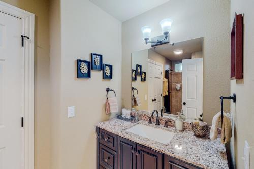 a bathroom with a sink and a large mirror at Urban Deck House in Eureka Springs