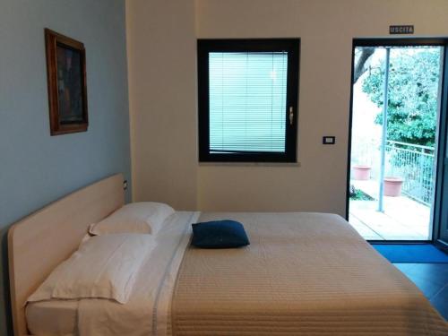 duże łóżko w sypialni z oknem w obiekcie Affittacamere arabafenice w mieście Vezzano Ligure