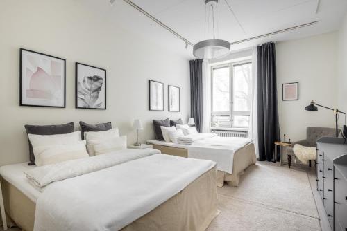 a white bedroom with two beds and a couch at Comfortable city home in Helsinki