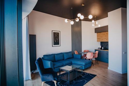 a living room with a blue couch and a table at JBHotels Apartament Premium Hanza Tower in Szczecin