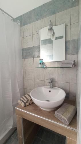 bagno con lavandino bianco e specchio di MAGDALINOS APPARTMENTS (4) a Nea Skioni