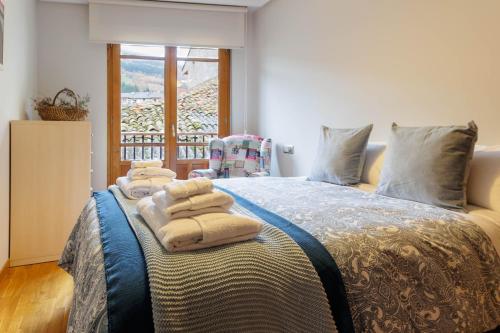 - une chambre avec un lit et des serviettes dans l'établissement Apartamento Otoño 2 - Apartamentos Nature, à Cangas del Narcea