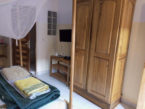 Un dormitorio con un gran armario de madera y una cama en Guesthouse Dalal ak Jàmm en Mbour