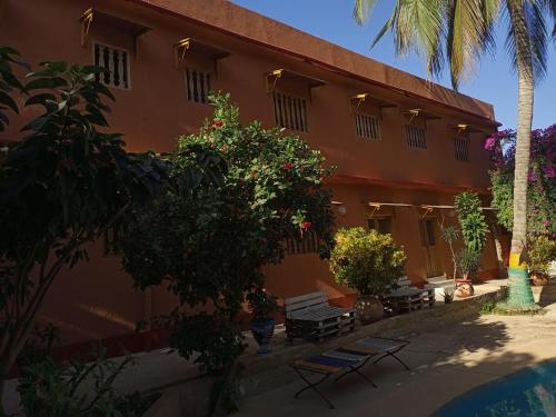a building with a group of benches in front of it at Guesthouse Dalal ak Jàmm in Mbour