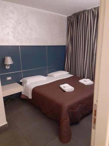 ein Schlafzimmer mit einem Bett mit zwei Handtüchern darauf in der Unterkunft FULL CASA in Cosenza