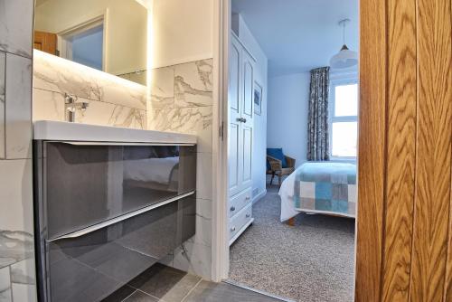 a kitchen with a sink and a stove at Spindrift - views of Chesil beach dog friendly in Weymouth
