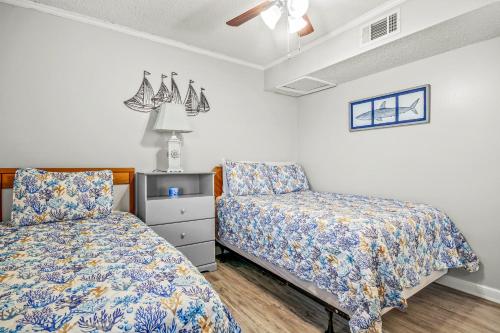 1 Schlafzimmer mit 2 Betten und einem Stuhl in der Unterkunft Waipani A-18 in Myrtle Beach