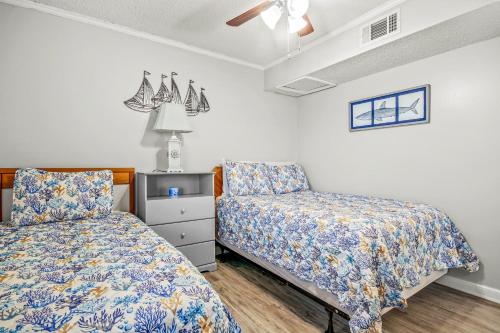 1 dormitorio con 2 camas y 1 silla en Waipani A-18, en Myrtle Beach