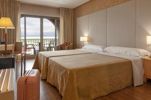 a hotel room with a large bed and a balcony at Hotel Macià Doñana in Sanlúcar de Barrameda