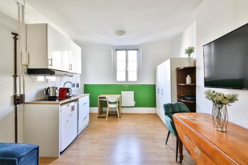 une cuisine avec une table et une cuisine aux murs verts dans l'établissement 41.Studio 2Pers#Sèvres-Lecourbe#Necker, à Paris