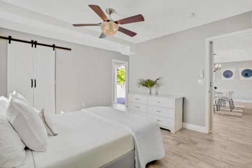 1 dormitorio con cama blanca y ventilador de techo en Pinellas Retreat, en Pinellas Park