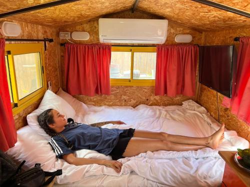 a man laying on a bed in a tent at Roger's Hostel Tel Aviv (age 18-45) in Tel Aviv