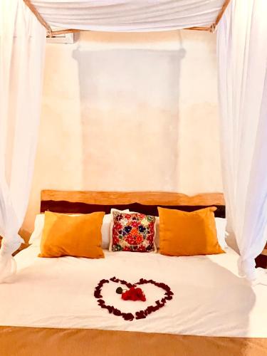 a bed with a heart drawn on it at Lodge Tzunum Jade in Tulum