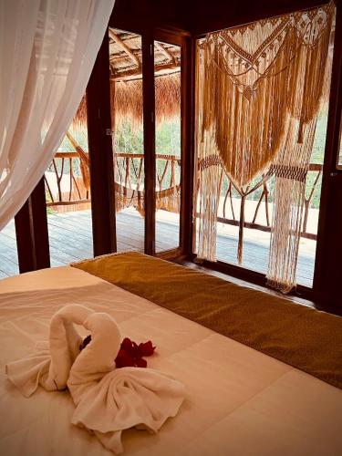 a swan made out of towels laying on a bed at Lodge Tzunum Jade in Tulum