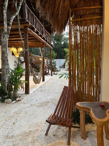 a wooden bench sitting outside of a resort with a hammock at Lodge Tzunum Jade in Tulum