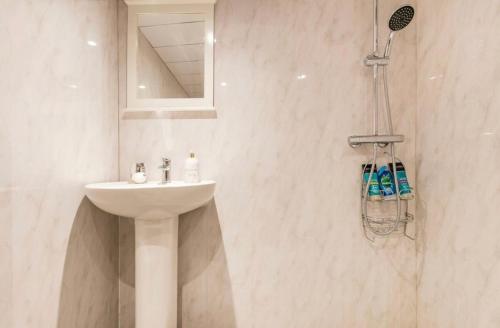 a white bathroom with a sink and a mirror at The hideaway in Bristol