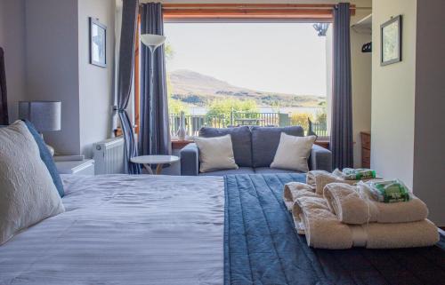 a bedroom with a large bed and a couch at Tarradale Cottage in Portree