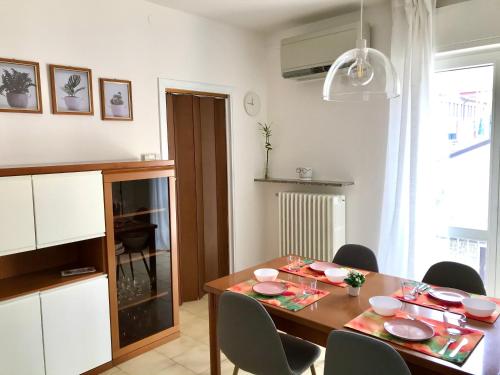 uma sala de jantar com uma mesa de madeira e cadeiras em IULI LAKE HOME Tra lago e montagna em Olginate