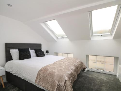 1 dormitorio con 1 cama y 2 ventanas en Butterfly Cottage, en Rossendale