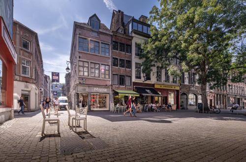uma rua da cidade com cadeiras e pessoas andando na rua em Les Cerisiers - Duplex de Standing au Centre de Namur em Namur