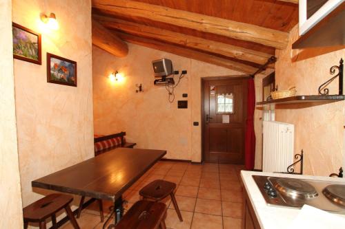 a kitchen with a table and chairs in a room at Residence Trompe-L'oeil in Champoluc