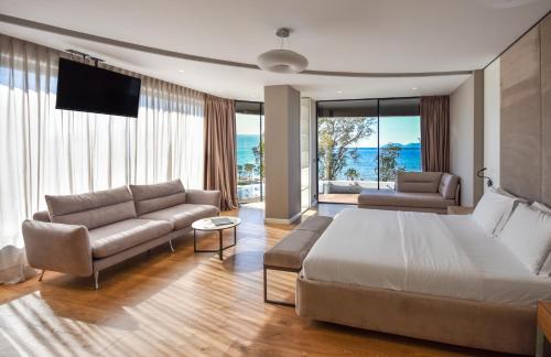 um quarto com uma cama, um sofá e uma televisão em Yacht Hotel em Vlorë