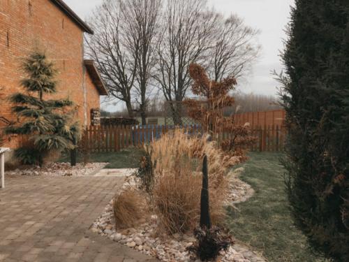 a garden with a fence and a brick yard at Au jardin de Victor in Saint-Rémy-en-Bouzemont-Saint-Genest-et-Isson