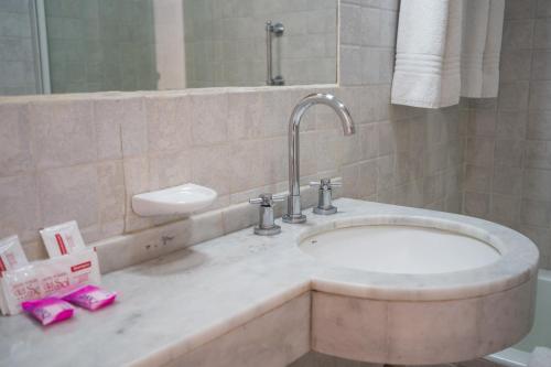 a bathroom with a sink and a mirror at Hotel Posada Del Sol in Salta