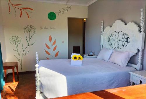 a bedroom with a white bed with a yellow box on it at Anoitecer Itinerante AL - antiga residencial o garfo in Ponte de Lima