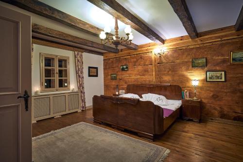 een slaapkamer met een bed in een kamer met houten wanden bij Modrzewiowy Dworek Kliczków Mały 